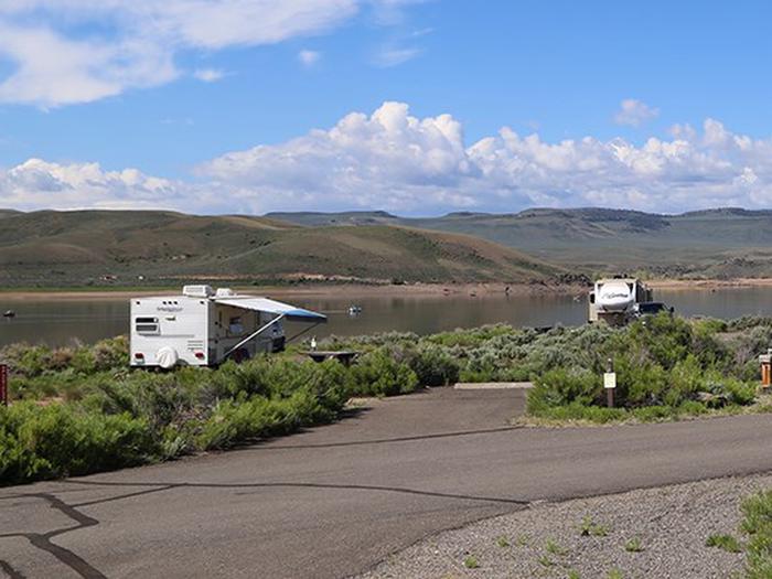 A campsite on the lake at Stevens Creek Campground with clouds in a blue sky