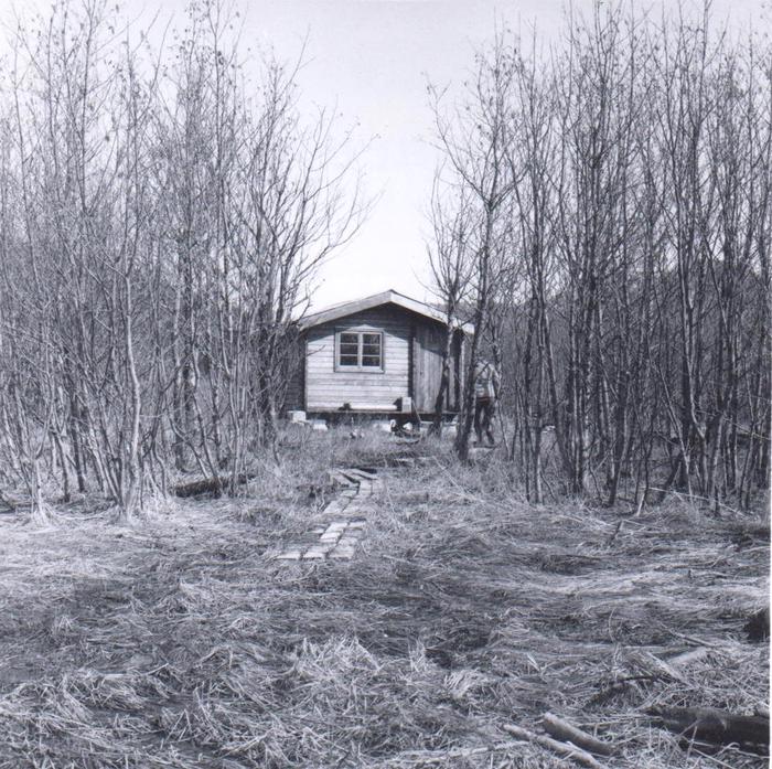 Black and white photo of Koknuk Cabin with leafless trees surrounding itKoknuk Cabin 1966
