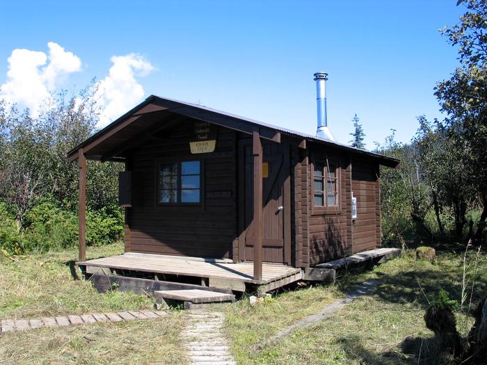 Koknuk cabin with two wood plank trails leading to it Koknuk Cabin