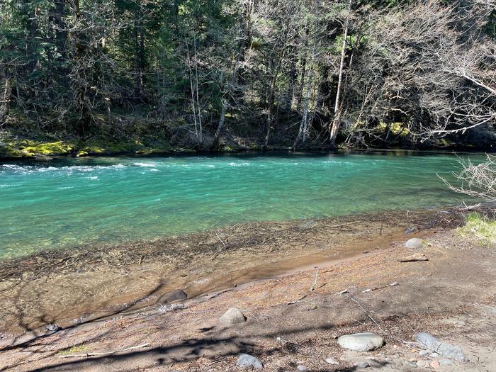 A sandy beach leads into a small and slow-moving river. The water is very clean and small trees overhang the opposite bank.Located near the Middle Fork River, Secret Campground offers great access to several swimming opportunities.