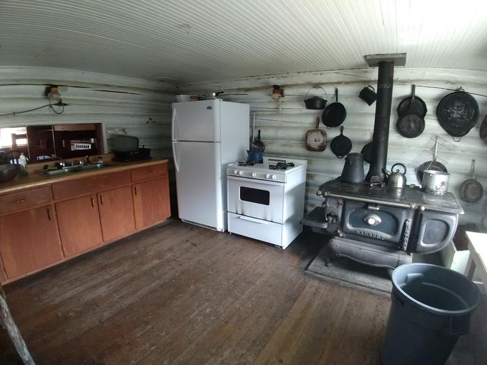 Kitchen with classic wood stove oven, modern oven and refrigerator