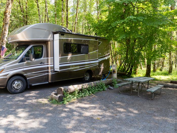 RV Campsite #14 with electric box, tree shaded area, and gravel parking.RV Campsite #14
