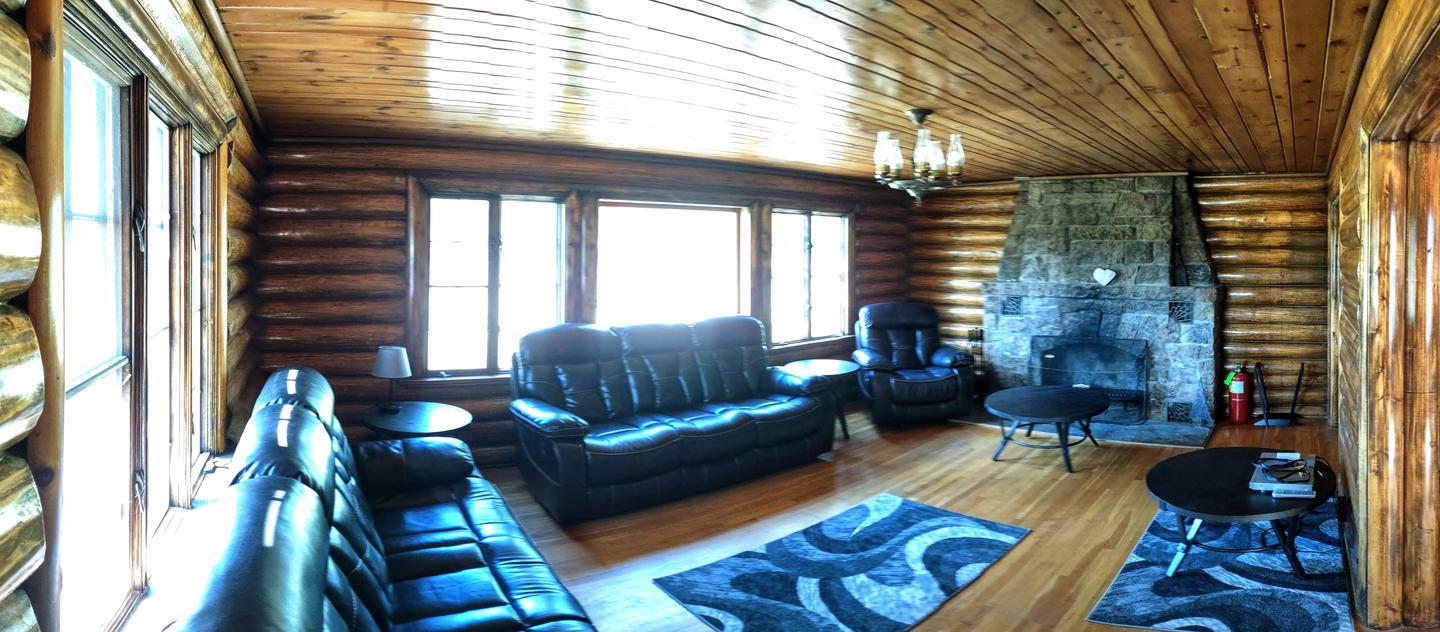 Redfeather Ranger Cabin: Living room showing stone fireplace, two couches, a chair, and rugs. Redfeather Ranger Cabin living room. 