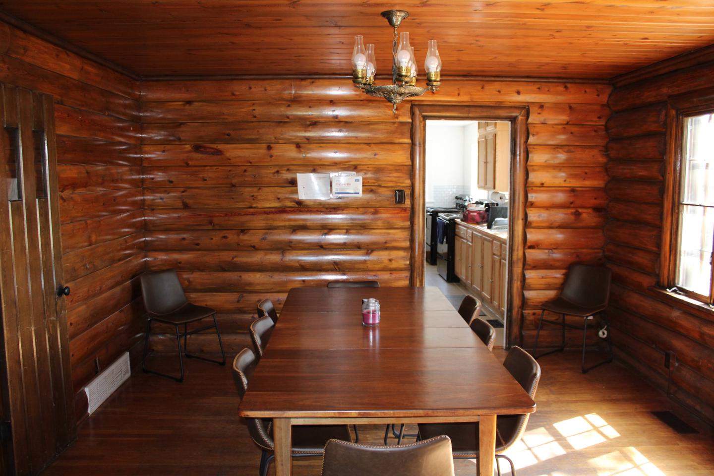 Redfeather Ranger Cabin dining room showing table with eight chairs, and chandelier.Redfeather Ranger Cabin dining room. 