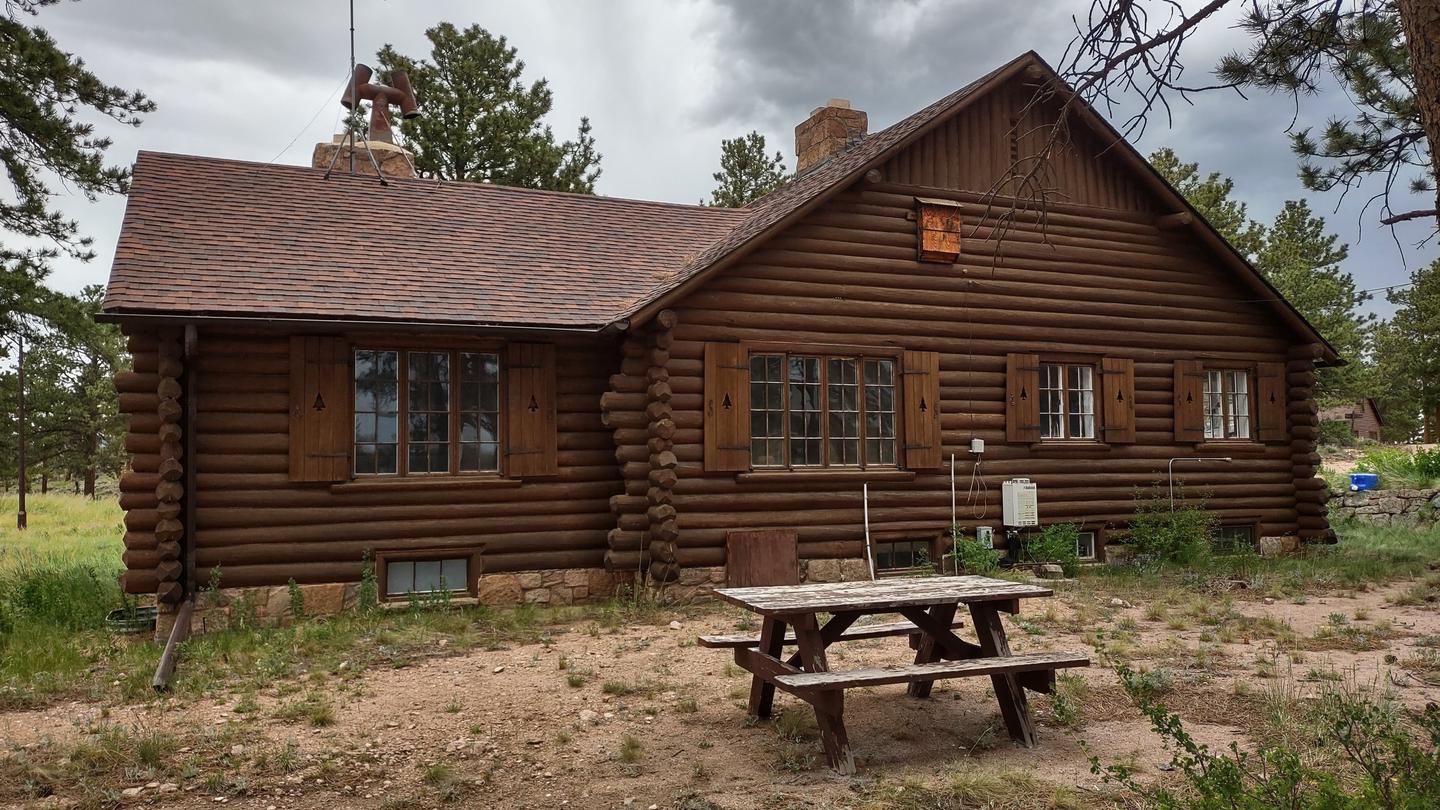 Log cabin with picnic table in foreground. Redfeather Ranger Cabin showing picnic table on east side of cabin. 