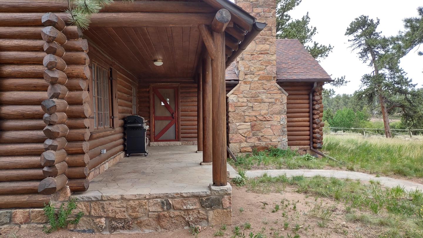 Log cabin with covered porch, grill, and stone walkway. Redfeather Ranger Cabin covered front porch. 