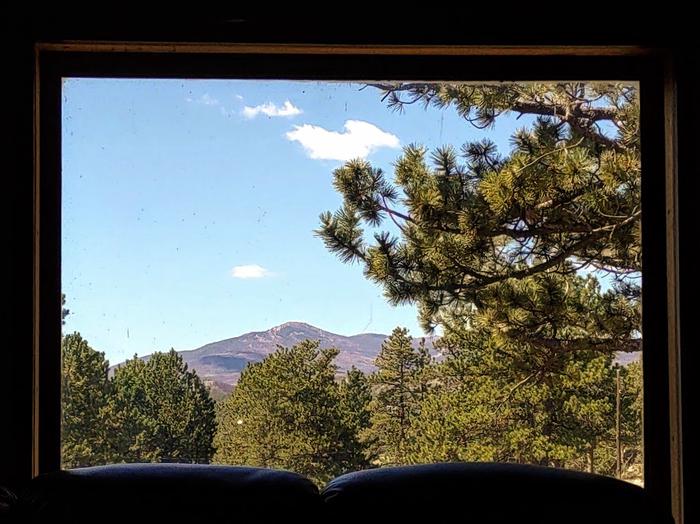 view of mountain and trees from inside a cabin. View of South Bald Mountain from living room. 