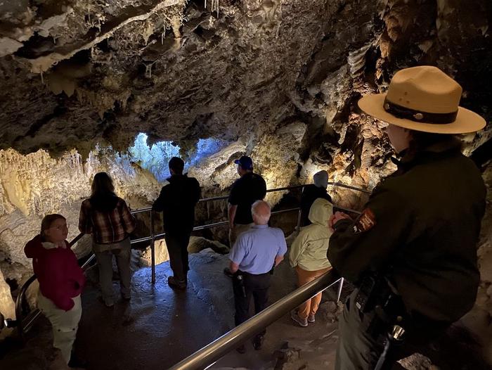 6 visitors standing below their ranger who is pointing out different cave formations in a highly decorated room in Timpanogos CaveTour group in the Chimes Chamber of Timpanogos Cave
