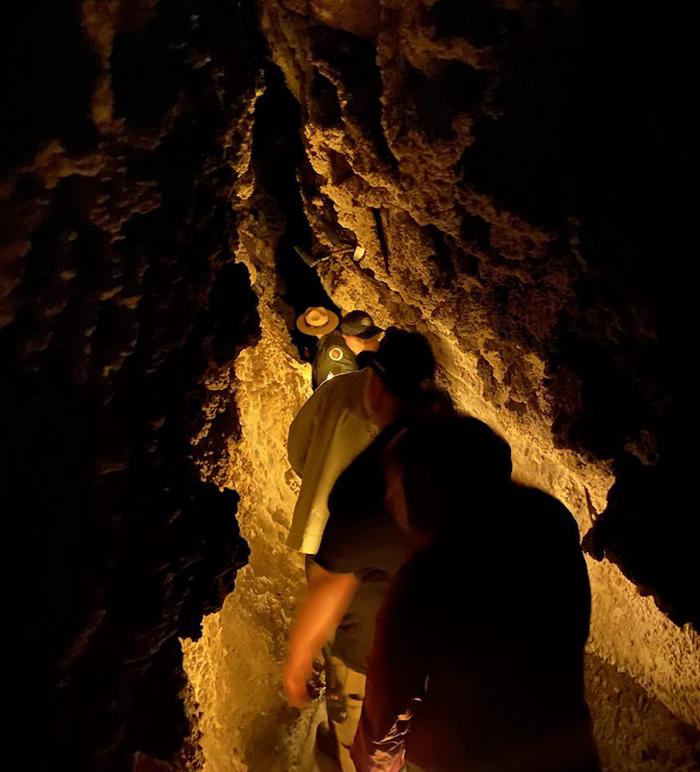 Visitors following a ranger through a narrow, dimly lit corridor in Middle CaveMiddle Cave Fault Line