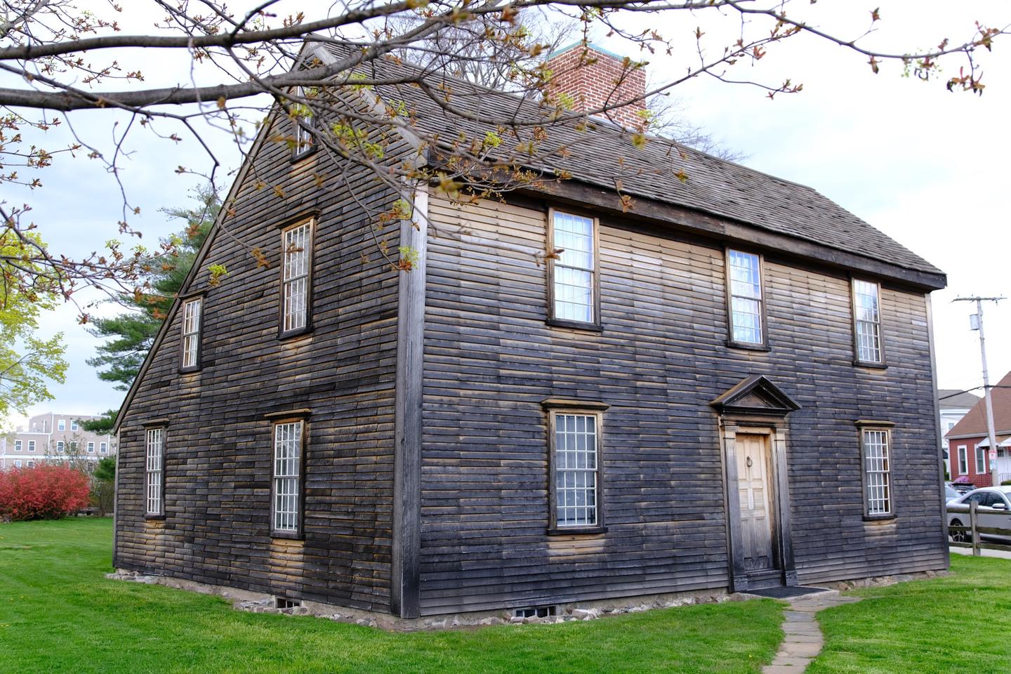 A New England "saltbox" style home with brown wood siding. The home where President John Adams was born in 1735.