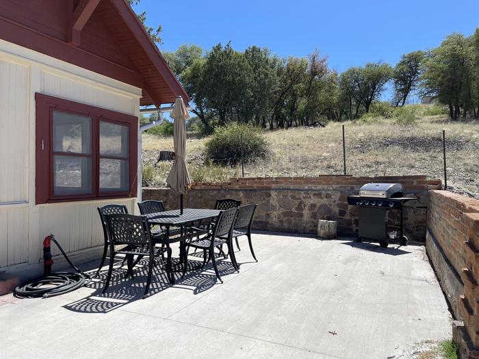 North Patio house entrance with table, chairs, and grill.