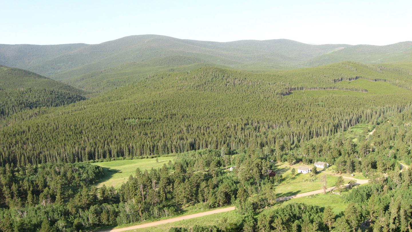 Mountain Valley with trees meadow and buildings and a road. Overview of Buckhorn Valley and Ranger Station