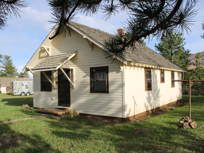 Building with grass trees and trailer in background. Buckhorn Ranger Dwelling. 