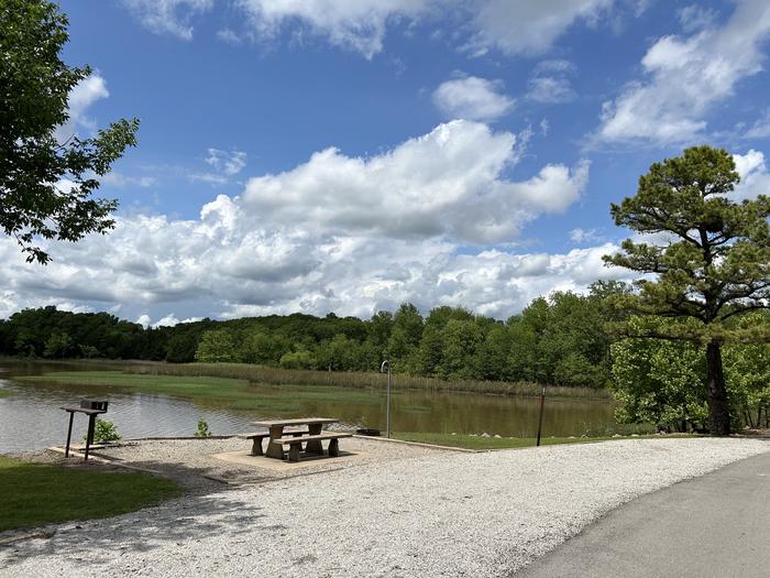 Site 2 is located along the roadway of the main road. Parking is parallel to the site.A photo of Site 2 of Loop  at Sunset Bay with Boat Ramp, Picnic Table, Fire Pit, Tent Pad, Waterfront, Lantern Pole