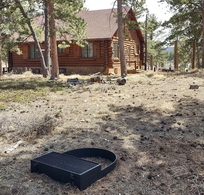 back of log cabin showing trees and fire ring.Redfeather Assistant Ranger Cabin showing fire ring. 