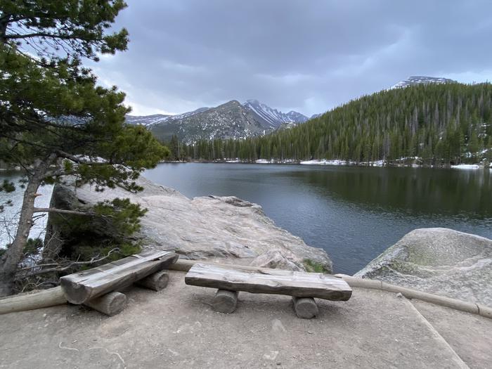 View of Bear Lake and distant mountain peaks from Bear Lake Trail. There are viewing benches along the trailView of Bear Lake in early summer