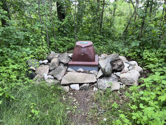 K11 - Happy Landing, privy at campsite with the toilet surrounded by rocks.Privy at campsite
