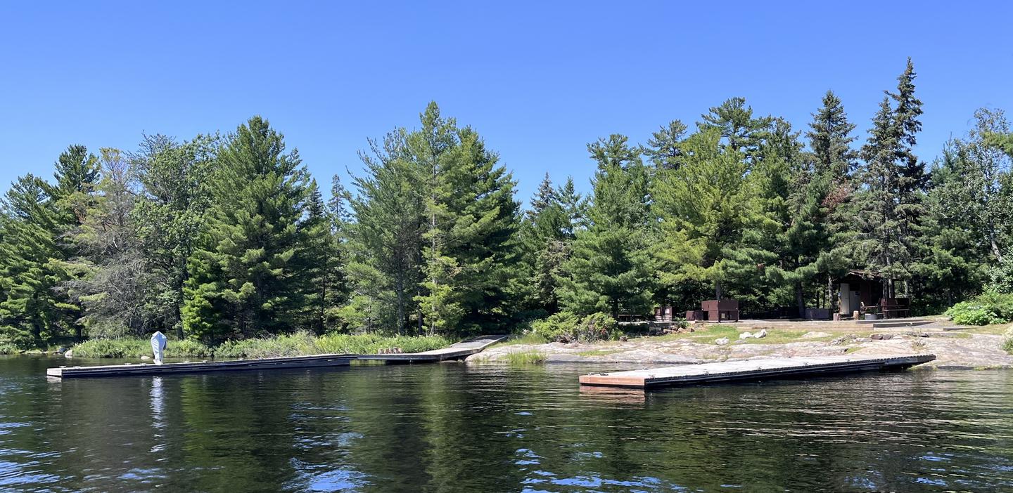 R74 - Rainy Lake Group, view of boat docks from water with accessible swing. View of campsite from the water