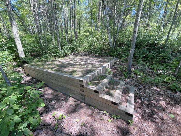 Mukooda Lake Crappie campsite, tent pad #2 with a couple of steps with tall trees in the backgroundTent Pad #2