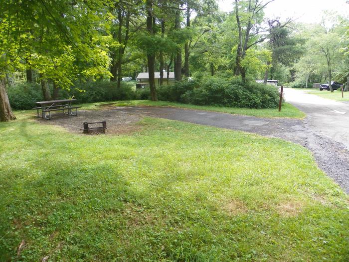 Campsite A99 has a level back in driveway, fire pit, picnic table, and grass tent pad. 