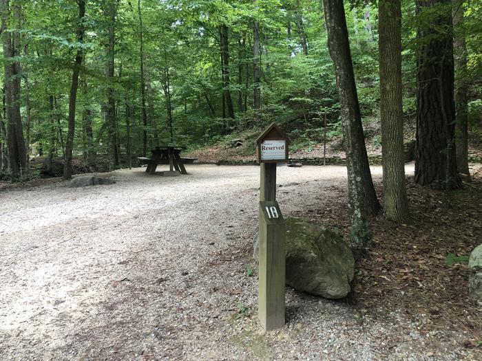 A photo of Site 018 of Loop CAVE MOUNTAIN LAKE FAMILY CAMP at CAVE MOUNTAIN LAKE FAMILY CAMP with Picnic Table, Fire Pit, Shade, Tent Pad, Lantern Pole