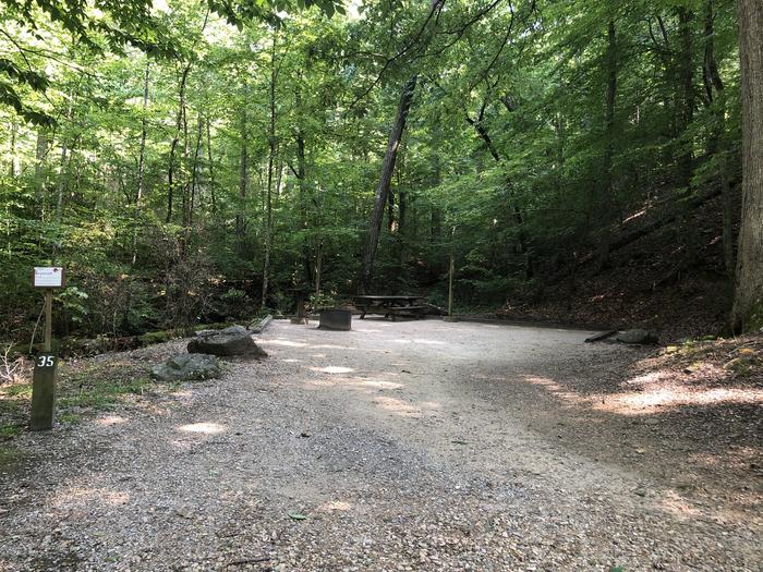 A photo of Site 035 of Loop B at CAVE MOUNTAIN LAKE FAMILY CAMP with Picnic Table, Fire Pit, Shade, Tent Pad, Lantern Pole