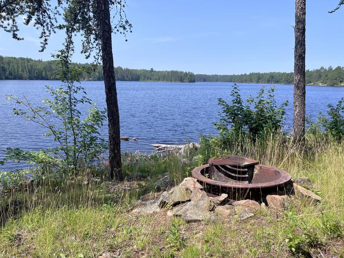 B12 - Olso Lake backcountry campsite, view looking out from campsite of the fire ring with water in the background.B12 - Olso Lake backcountry campsite