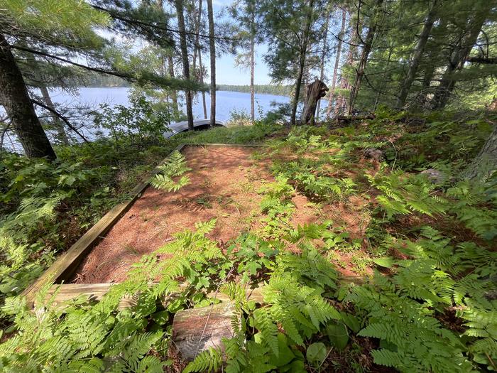 Oslo lake tent pad with view of canoe and water in background.Tent pad