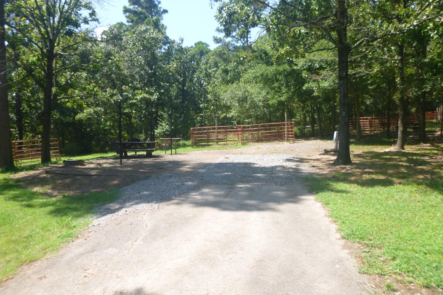 Site E6 with horse pen, picnic table, fire ring, grill, lantern posts, electric hookup, water hookupSite E6.