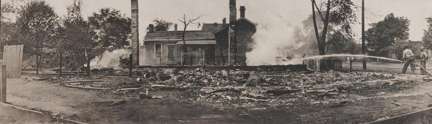 Destroyed Home at 9th and Madison StreetsTwo people attempt to extinguish a burning building in 1908.