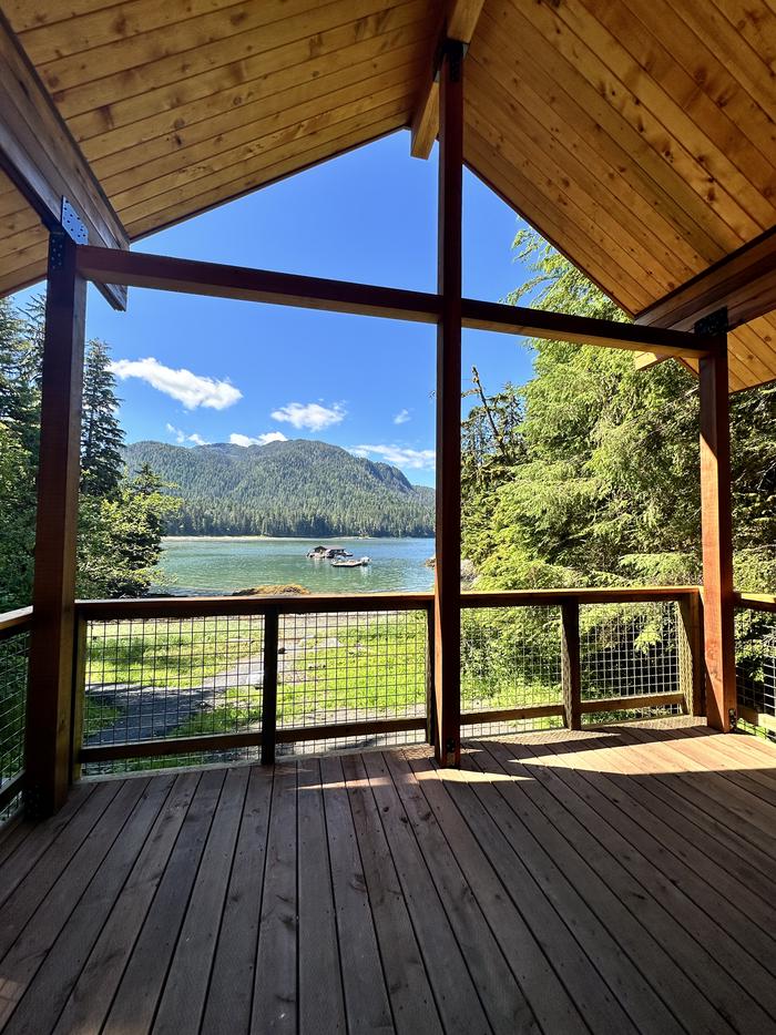 Deck with view of boat and floathouse in bay and mountains in background.View from the front deck