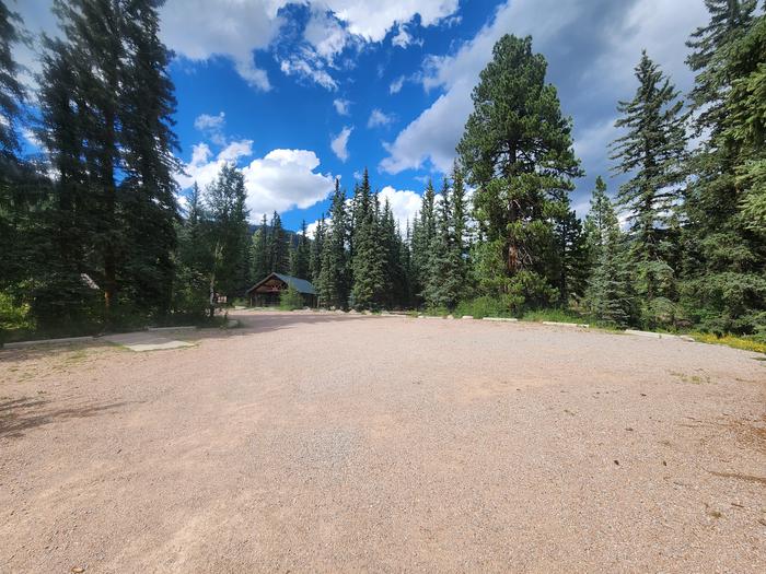 Large circle parking area for vehicles and campers. Tents can be scattered in the surrounding woods.