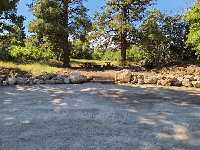 Large gravel parking area and stairs leading to picnic tables and fire ring.Price Canyon campsite 1 and parking area