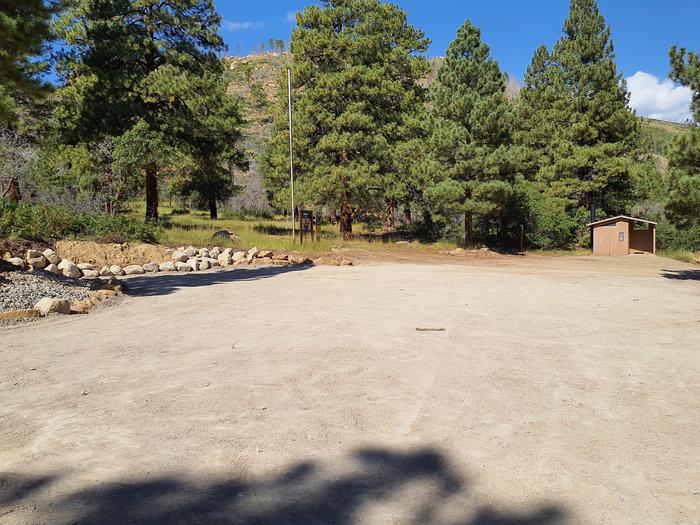 Large gravel parking area for group site and restroom in the background.Price Canyon group campsite 2 parking area