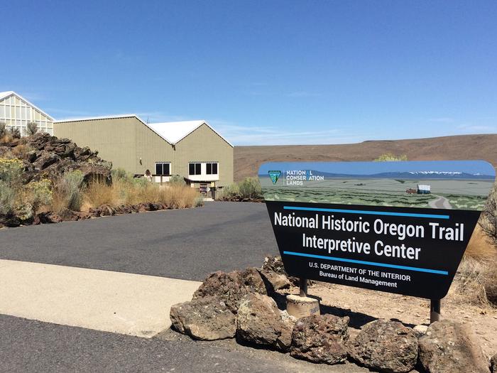 Sign reading National Historic Oregon Trail Interpretive center with a path on the left leading to a building in the distanceEntrance into the Museum