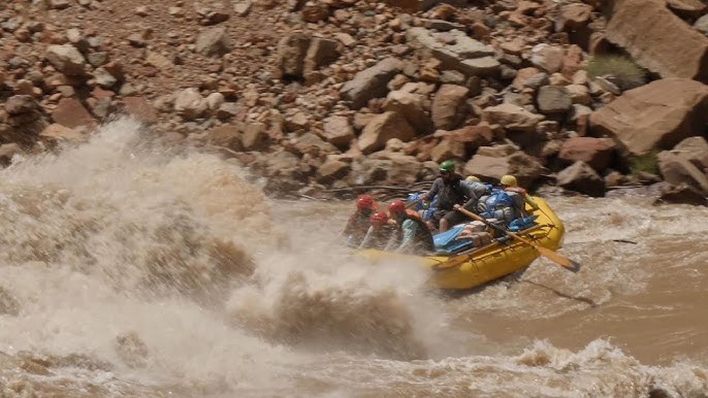 A yellow raft enters a whitewater rapid in Cataract CanyonA yellow raft approaches a whitewater rapid in Cataract Canyon