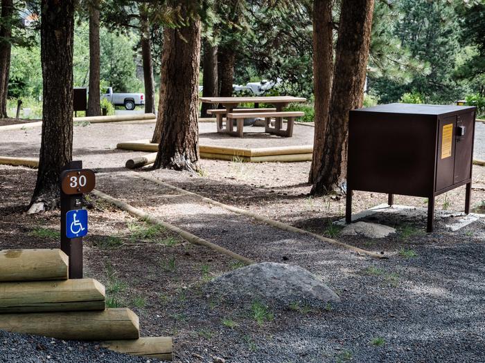 View of a parking space and food storage box in Aspenglen Campground