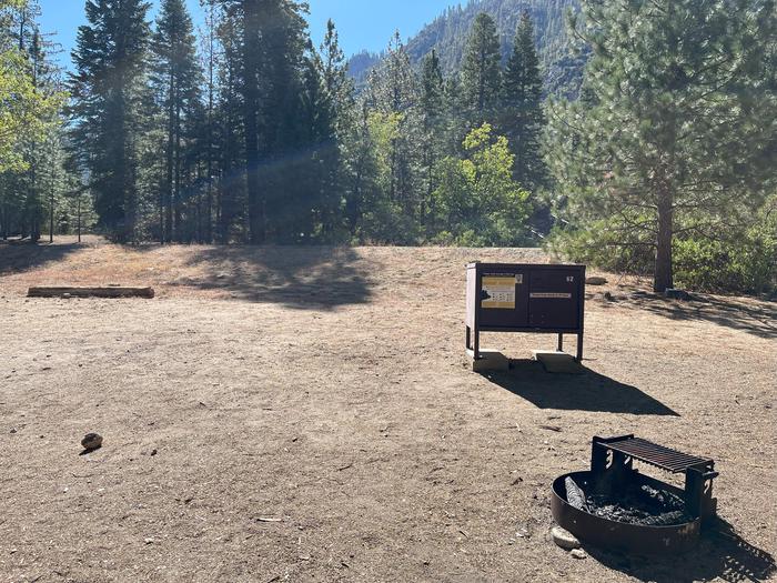 Smooth dirt tent pad surrounded by trees and near fire ring and bear boxTent Pad
