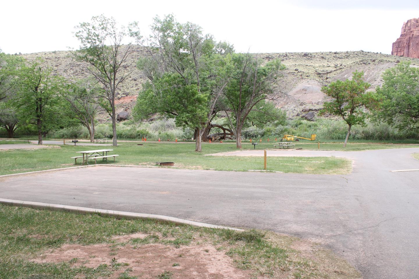 A paved driveway. Facing the end of the driveway, a picnic table and fire pit is fire pit is on the right side. Site 11, Loop A in summer.
Paved Dimensions: 31' x 31'