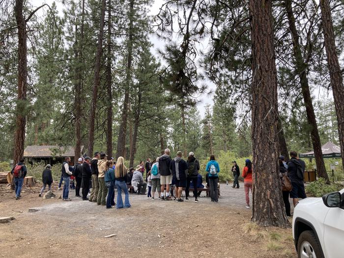 Outside cave, people standing around ranger speakingVisitors will attend a brief cave orientation about safety and white nose syndrome. 