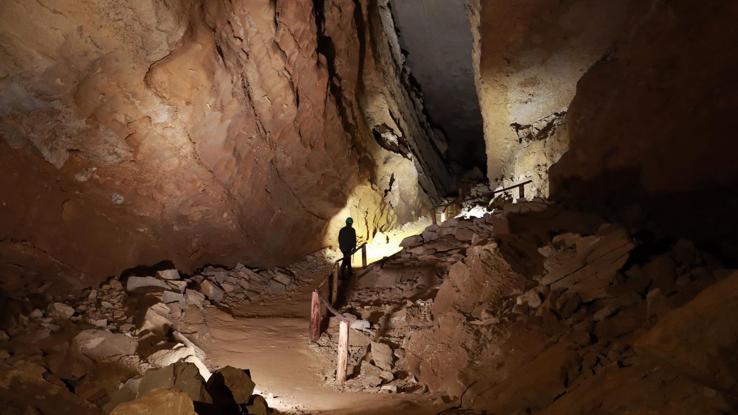 Visitors walking up a hill within a dimly lit cave Crystal Cave Hill Climb