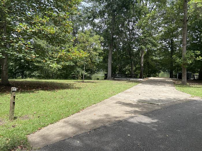 A photo of Site 032 of Loop PRAIRIE CREEK (AL) at PRAIRIE CREEK (AL) with Picnic Table, Electricity Hookup, Fire Pit, Shade, Waterfront, Lantern Pole