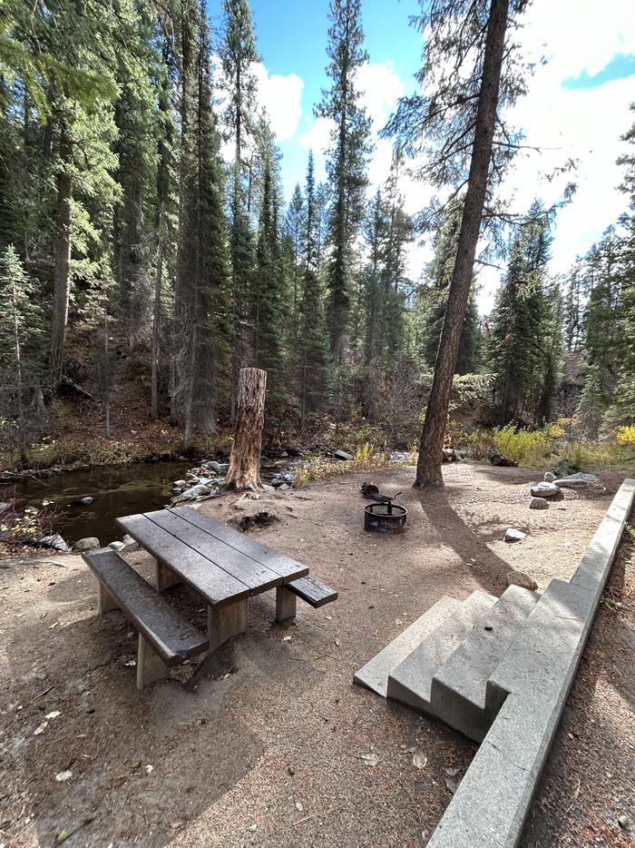 Stairs that lead down to campsite with picnic table and fire ring adjacent to a creekTen Mile Site 2