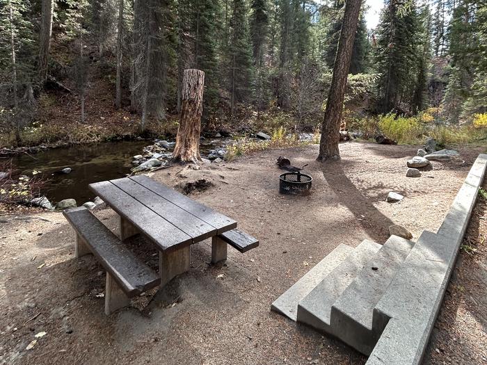 Stairs lead to creekside campsite with picnic table and fire ring.Ten Mile Site 2