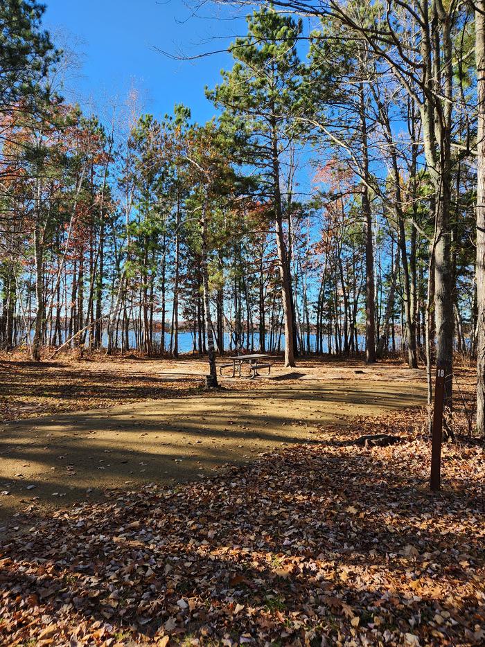 A picture of a campsite in Mabel Lake Campground with trees, a site marker, and a picnic table.A campsite in Mabel Lake Campground.