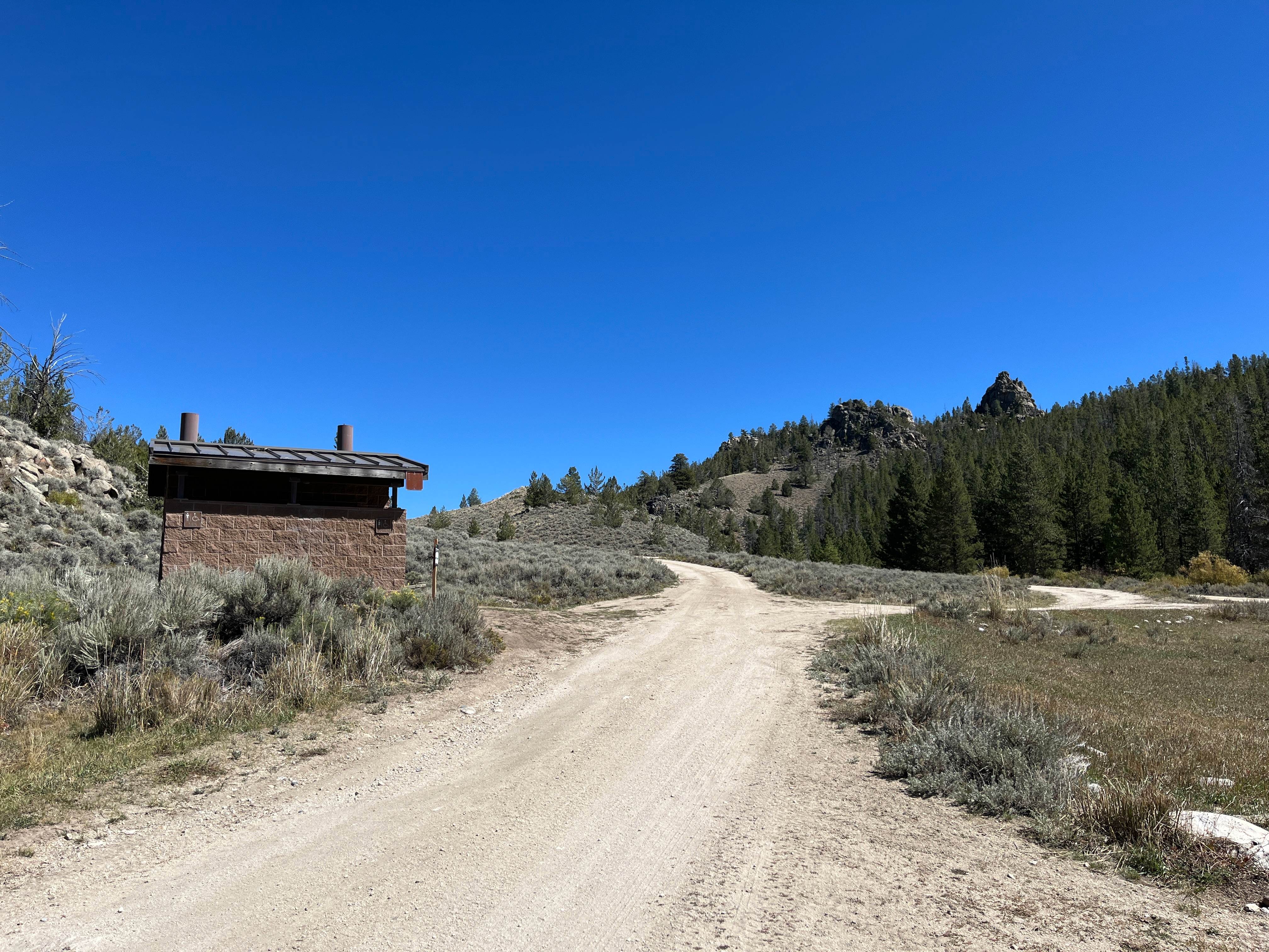 View of double vault toilets and road leading to two drive-up campsites
