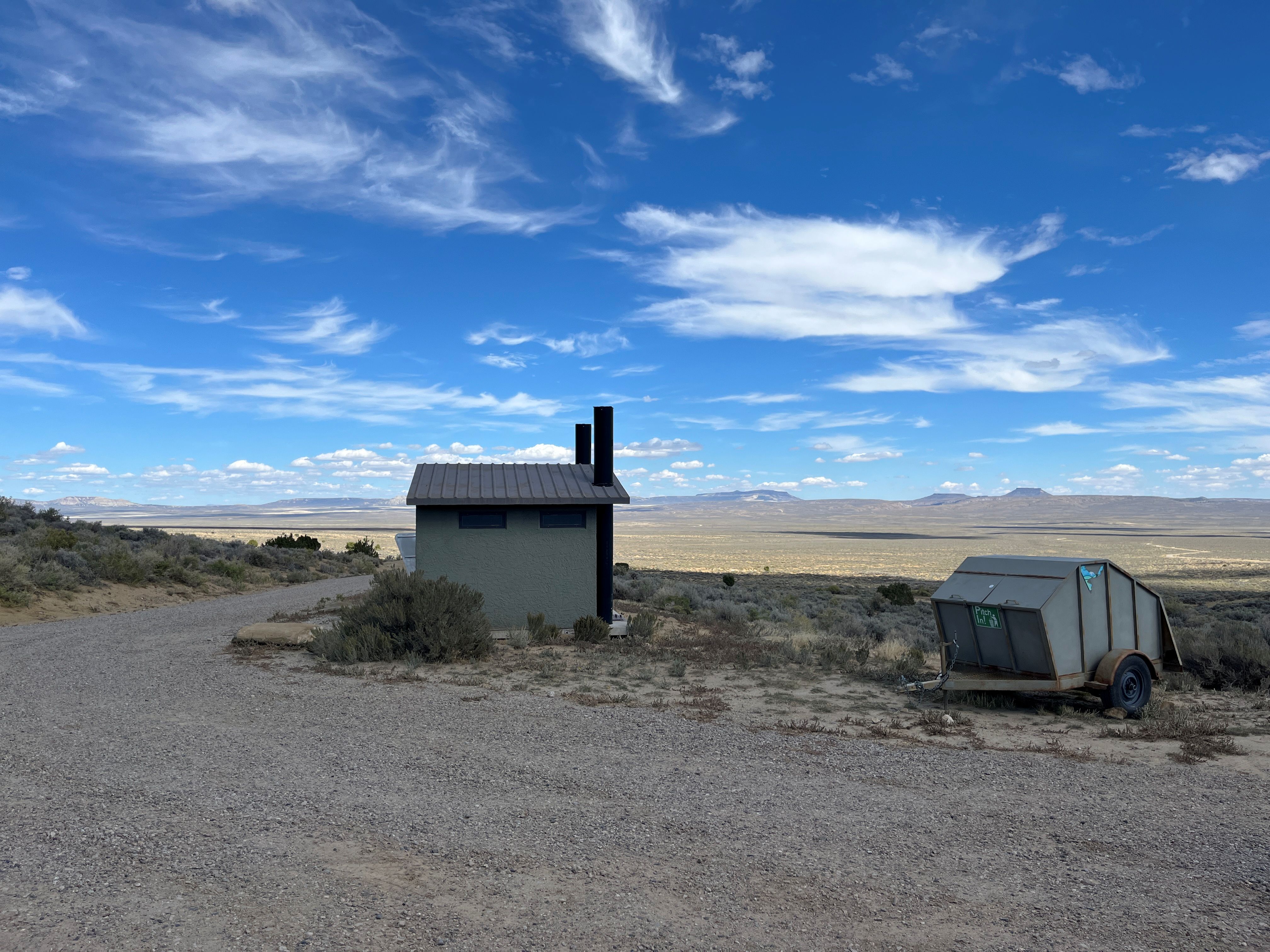 Parking area with vault toilets and trash bin