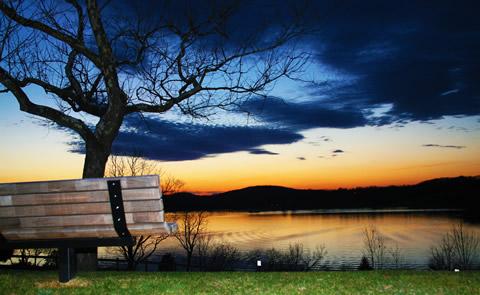 park bench near the lake at sunset