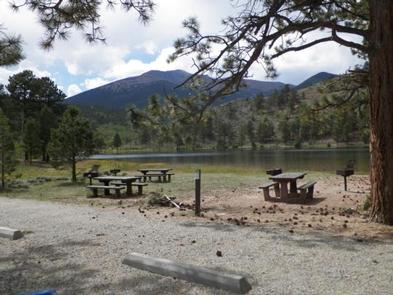 Picnic tables near lake with mountains in backgroundDay Use area with picnic tables