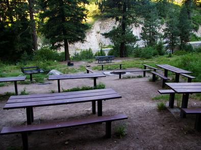 Benches and picnic tables by a sunken fire pit.This grouping of tables also features an in-ground fire pit.